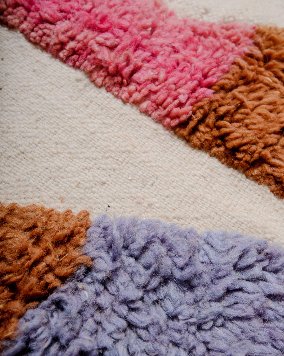 Detail of fluffy knotted wool contrasting with flat-woven base of berber rug.
